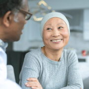 Beautiful Korean woman with cancer smiles at doctor